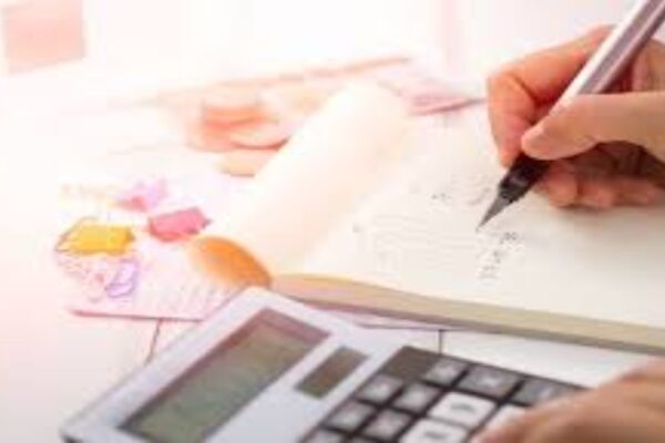 writing on a notepad and using calculator